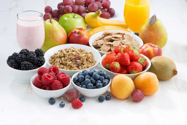 Fresh berries, fruit and muesli for breakfast on white — Stockfoto