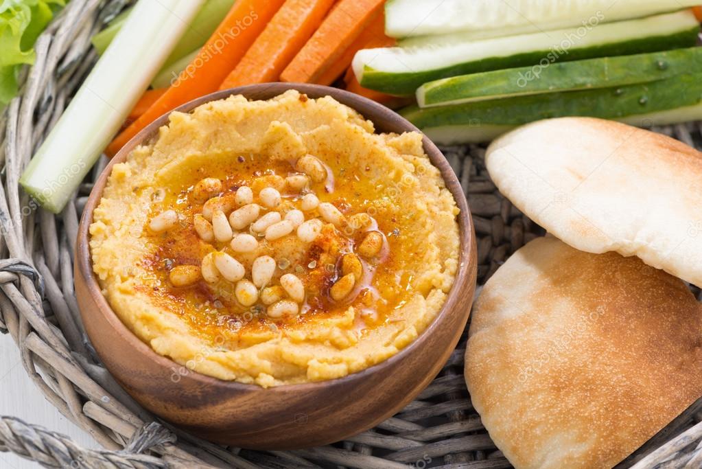 Hummus with pita bread and fresh vegetables, top view — Stock Photo