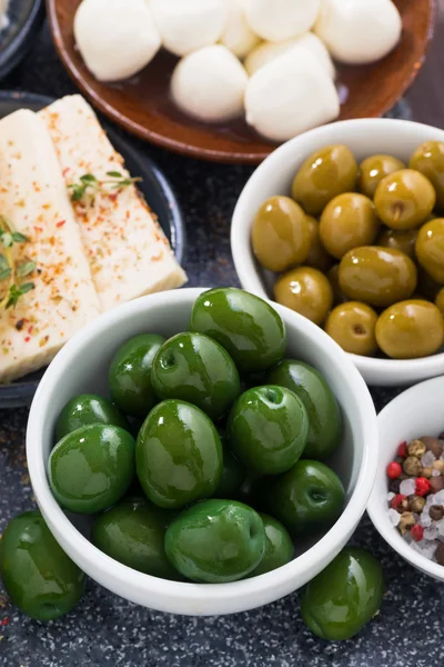 Snacks - green olives and soft cheeses, vertical, top view — Stockfoto