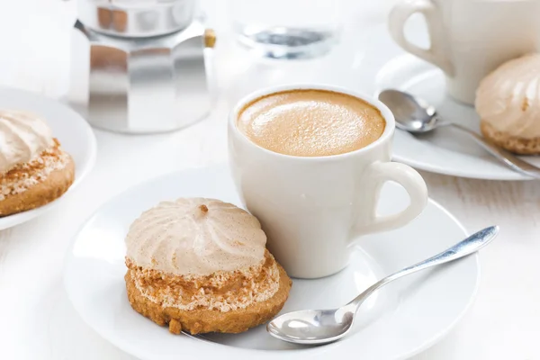 Cappuccino fresco e bolos na mesa branca — Fotografia de Stock