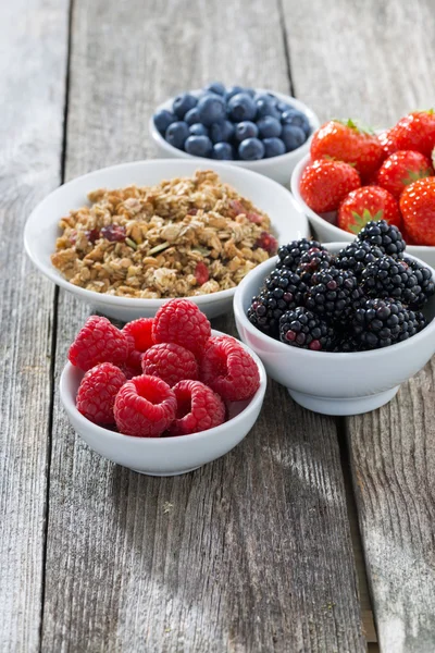 Garden berries and muesli on wooden background, vertical — ストック写真