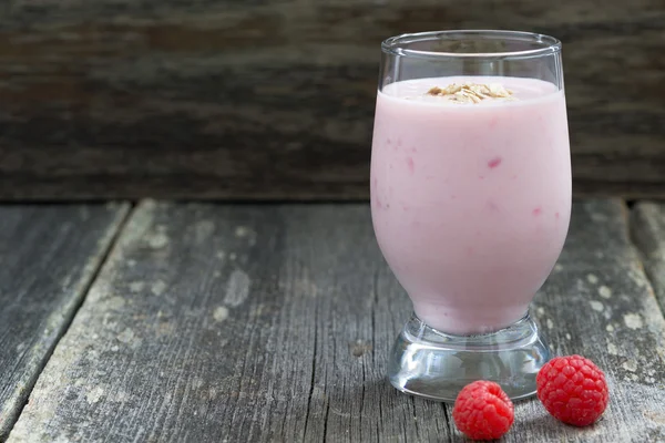 Milkshake with raspberries on a wooden background, close-up — Stok fotoğraf