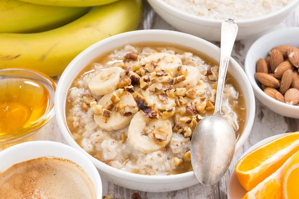 Hälsosam frukost - havregrynsgröt med banan, honung och valnötter — Stockfoto