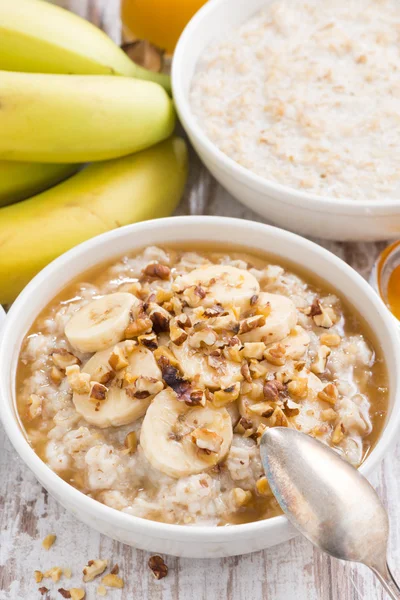 Hälsosam frukost - havregrynsgröt med banan, honung och valnötter — Stockfoto