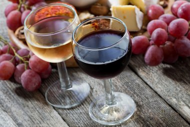 glass of white and red wines, appetizers on a wooden table clipart