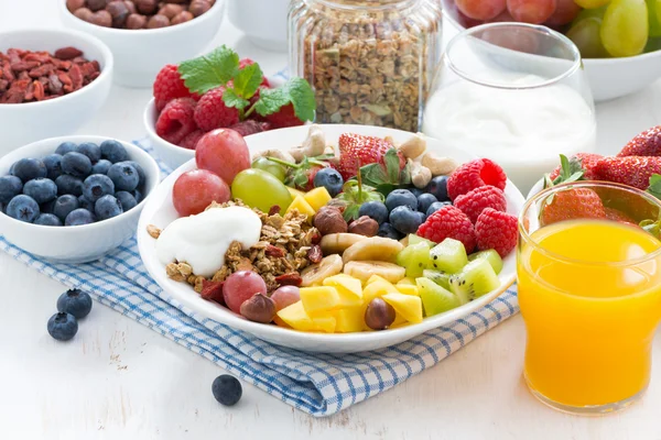 Bayas, frutas, frutos secos y granola en el plato — Foto de Stock