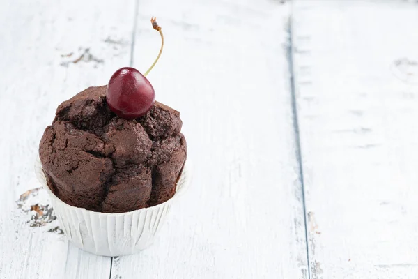 Gâteau au chocolat aux cerises sur fond blanc vintage en bois — Photo