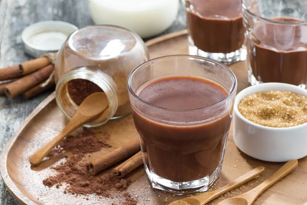 Glass of cocoa with spices on a wooden tray, close-up — Stock Photo, Image