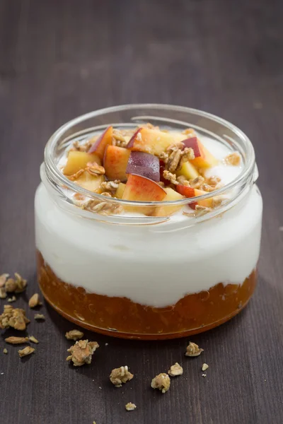 Postre con crema, granola y mermelada de melocotón, vertical, primer plano —  Fotos de Stock