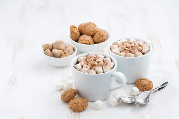 Due tazze di cacao aromatizzato con marshmallow e biscotti su bianco — Foto Stock