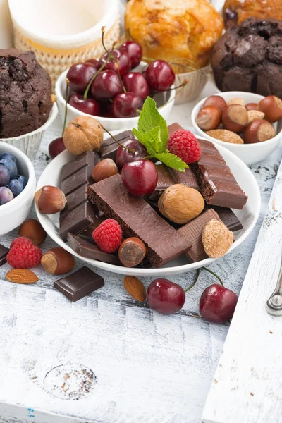 Sortimento de chocolate, bagas e nozes no fundo branco — Fotografia de Stock