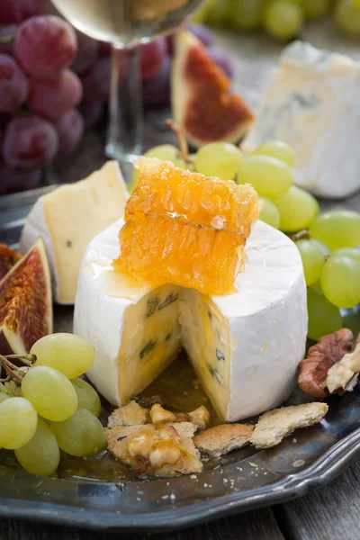 Camembert con miel y fruta, aperitivos y vino en un plato —  Fotos de Stock