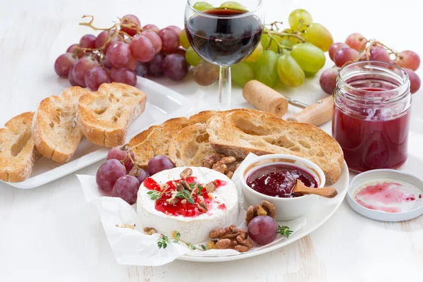 Aperitivos para el vino - camembert con mermelada de bayas, tostadas y frutas — Foto de Stock