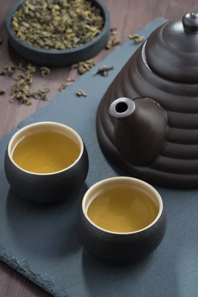 freshly brewed green tea in ceramic ware, vertical
