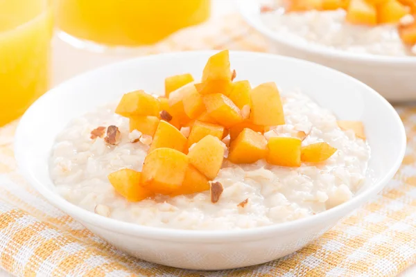 Bowl of oatmeal with fresh apricots and orange juice, close-up — Stock Photo, Image