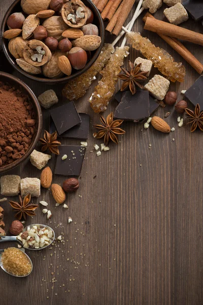 Cioccolato, cacao, noci e spezie su sfondo in legno vista dall'alto — Foto Stock