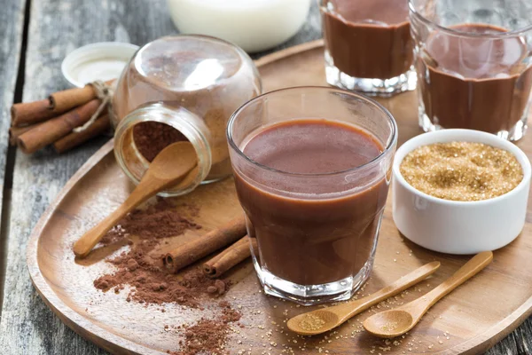 Glass of cocoa with spices on a wooden tray — Stock Photo, Image