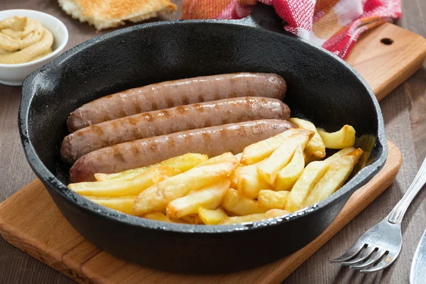 grilled sausages with French fries for lunch, close-up