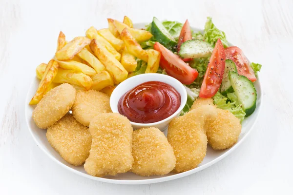 Chicken nuggets, french fries and vegetable salad — Stock Photo, Image