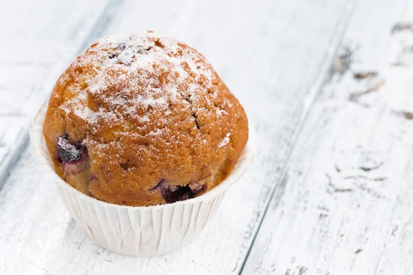 Muffin aux raisins secs et sucre glace sur fond de bois blanc — Photo