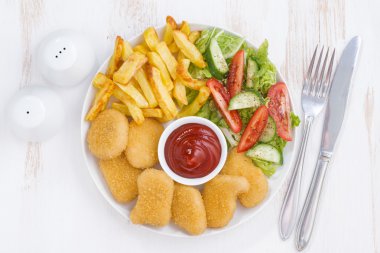 tavuk nuggets, kızarmış patates ve sebze salatası, üstten görünüm