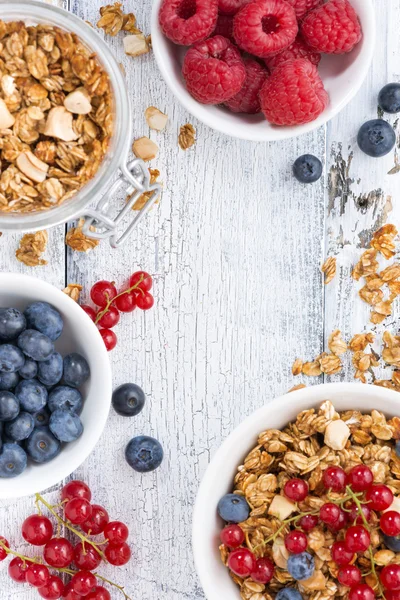 Granola y bayas frescas sobre fondo de madera blanca — Foto de Stock