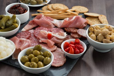 Şarküteri et aperatifler, sosis ve bir kara tahta üzerinde turşu