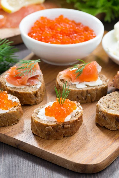 Appetizers - toast with salted salmon and red caviar, vertical — Stock Photo, Image