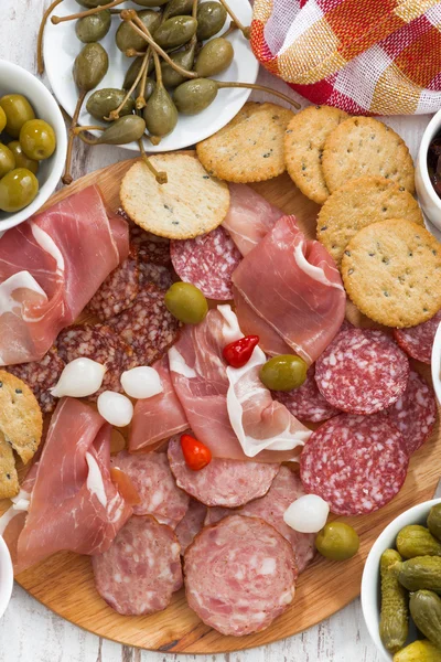 Snack di carne assortiti, salsicce e sottaceti su tavola di legno — Foto Stock