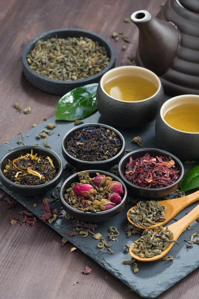 Assortment of fragrant dried teas and green tea on wooden table — Stock Photo, Image