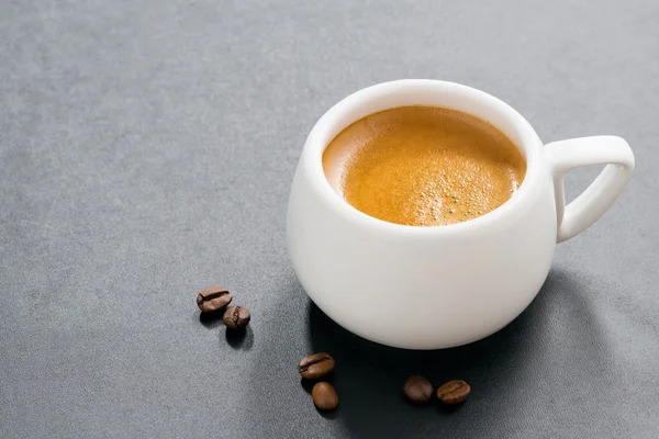 Upp av espresso på en mörk bakgrund och kaffebönor — Stockfoto