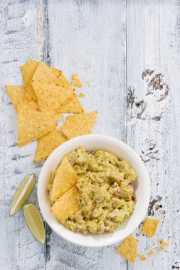 Baharatlı avokado sosu ve mısır cipsi Beyaz ahşap zemin üzerinde