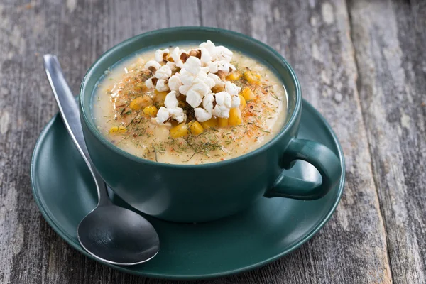 Sopa de maíz con palomitas de maíz en taza de cerámica en la mesa de madera —  Fotos de Stock