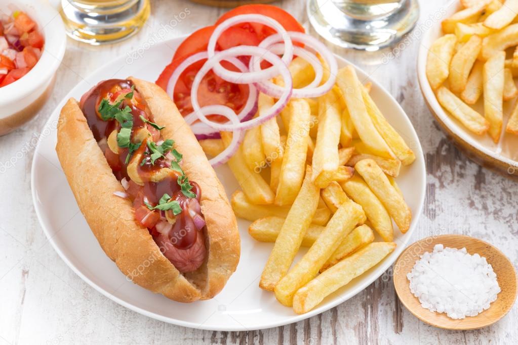 fast food - hot dog with French fries and chips on wooden table