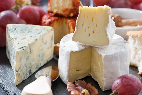 Geformter Käse und Snacks an der Tafel, Nahaufnahme — Stockfoto