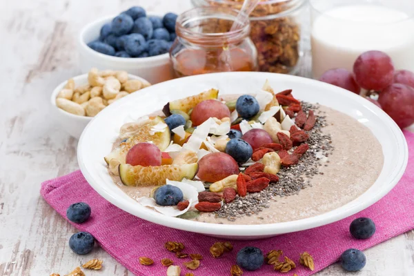 Oatmeal with assorted fresh fruits, nuts and chia in plate — Stock Photo, Image