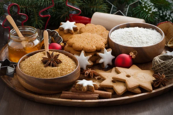 Weihnachtsplätzchen und Zutaten zum Backen auf Holzblech — Stockfoto