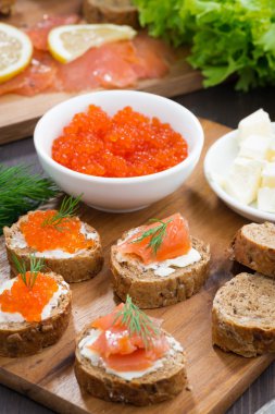 tost ahşap tahta üzerinde tuzlanmış somon ve kırmızı havyar ile