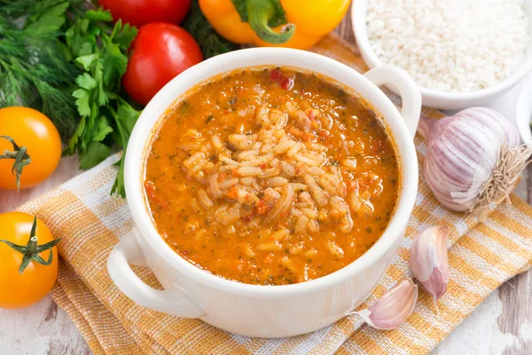 Томатный суп с рисом и овощами в белой кастрюле — стоковое фото