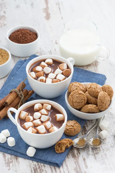 Cacau com marshmallows e biscoitos de amêndoa na mesa de madeira branca — Fotografia de Stock