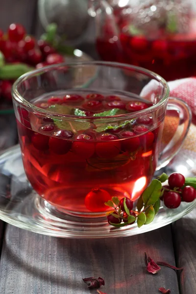 Berry tea in cup on dark wooden table — Stock Photo, Image