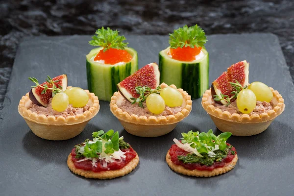 Set of festive Christmas appetizers on a dark background — Stock Photo, Image