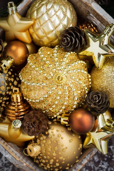 Wooden box with golden Christmas decorations, top view, closeup — Stock Photo, Image