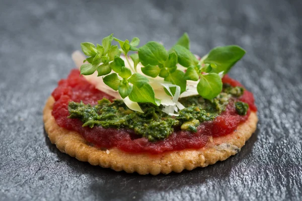 Cracker avec pâté de betterave et pesto sur un fond sombre — Photo