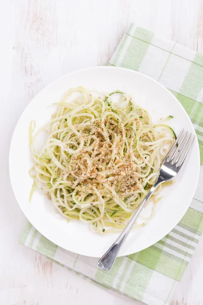 Vegetarian pasta with zucchini and nuts, top view, vertical — Stock Photo, Image