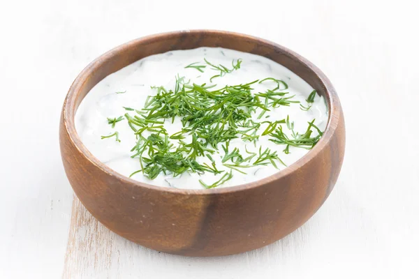 Yoghurt sauce with herbs in a wooden bowl — Stock Photo, Image