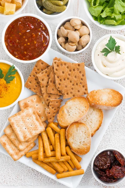 Assortment breads, crackers and sauces, top view — Stock Photo, Image