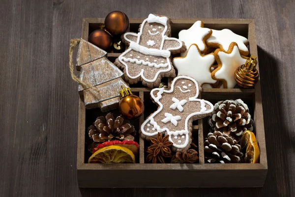 Símbolos de Navidad en una caja de madera sobre fondo de madera oscura — Foto de Stock