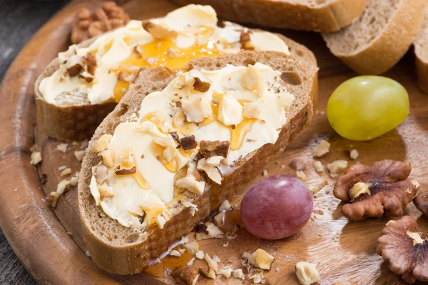 Хлеб с маслом, медом и орехами, крупным планом — стоковое фото