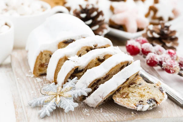 Christmas Stollen on a wooden board and cookies, closeup — Stock Photo, Image